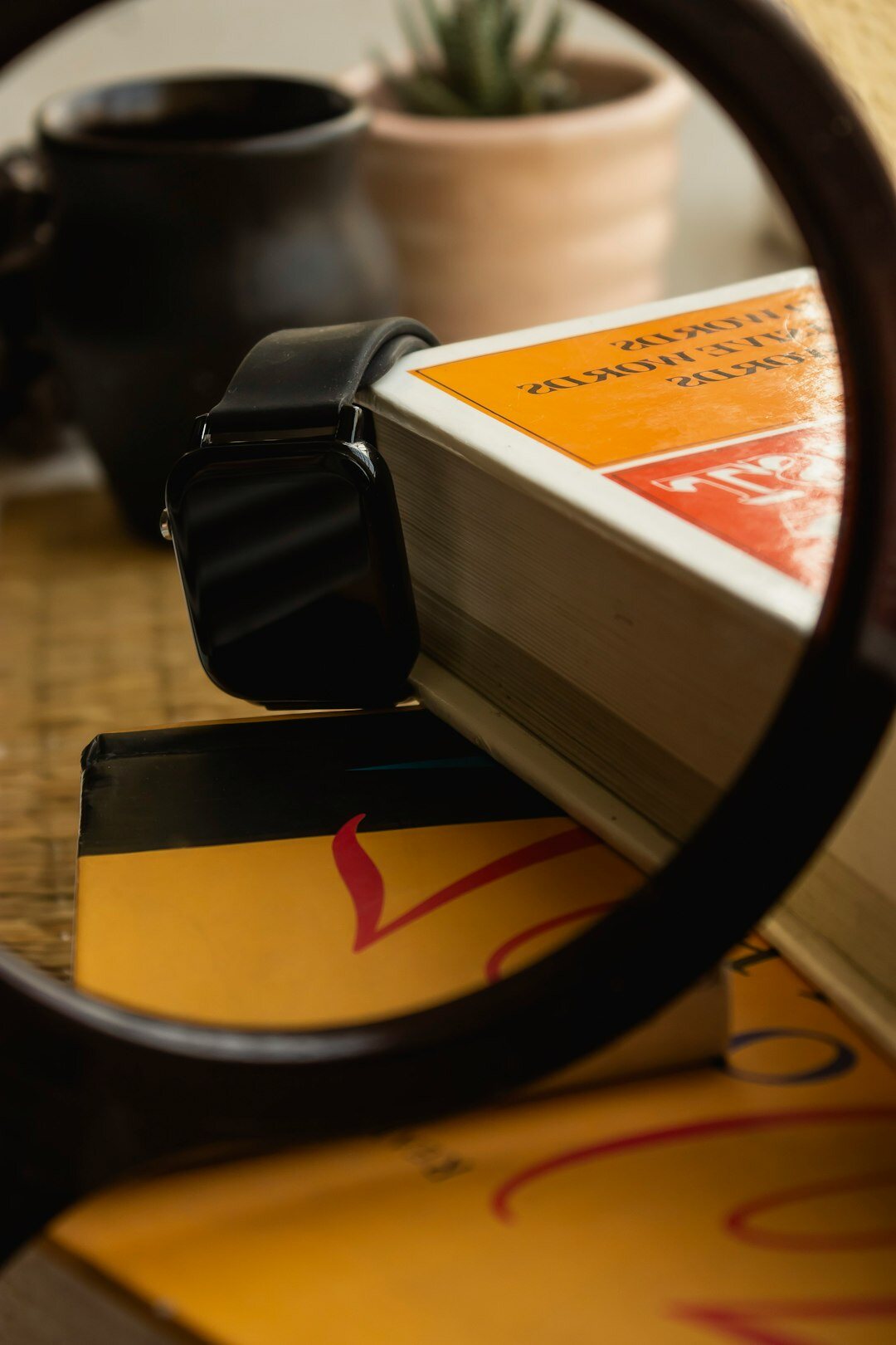 Magnifying glass resting on old photographs and documents on a wooden desk