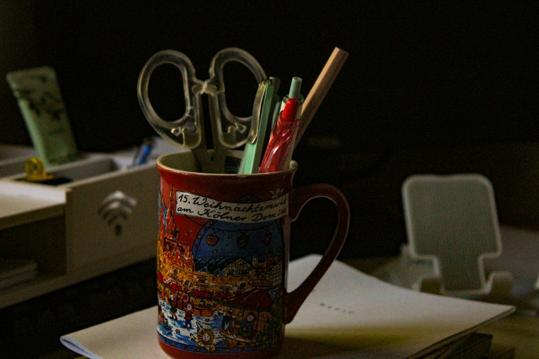Detective notebook, fountain pen and coffee cup on a desk with newspaper clippings