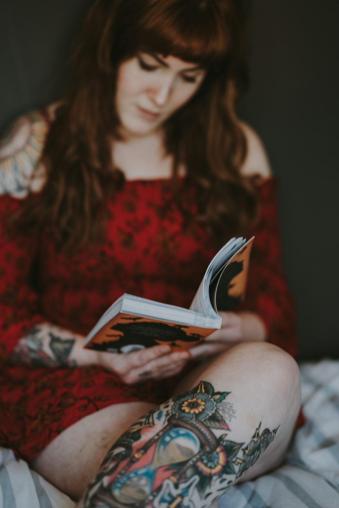 Studio portrait of a young Uruguayan woman holding a mystery novel, smiling